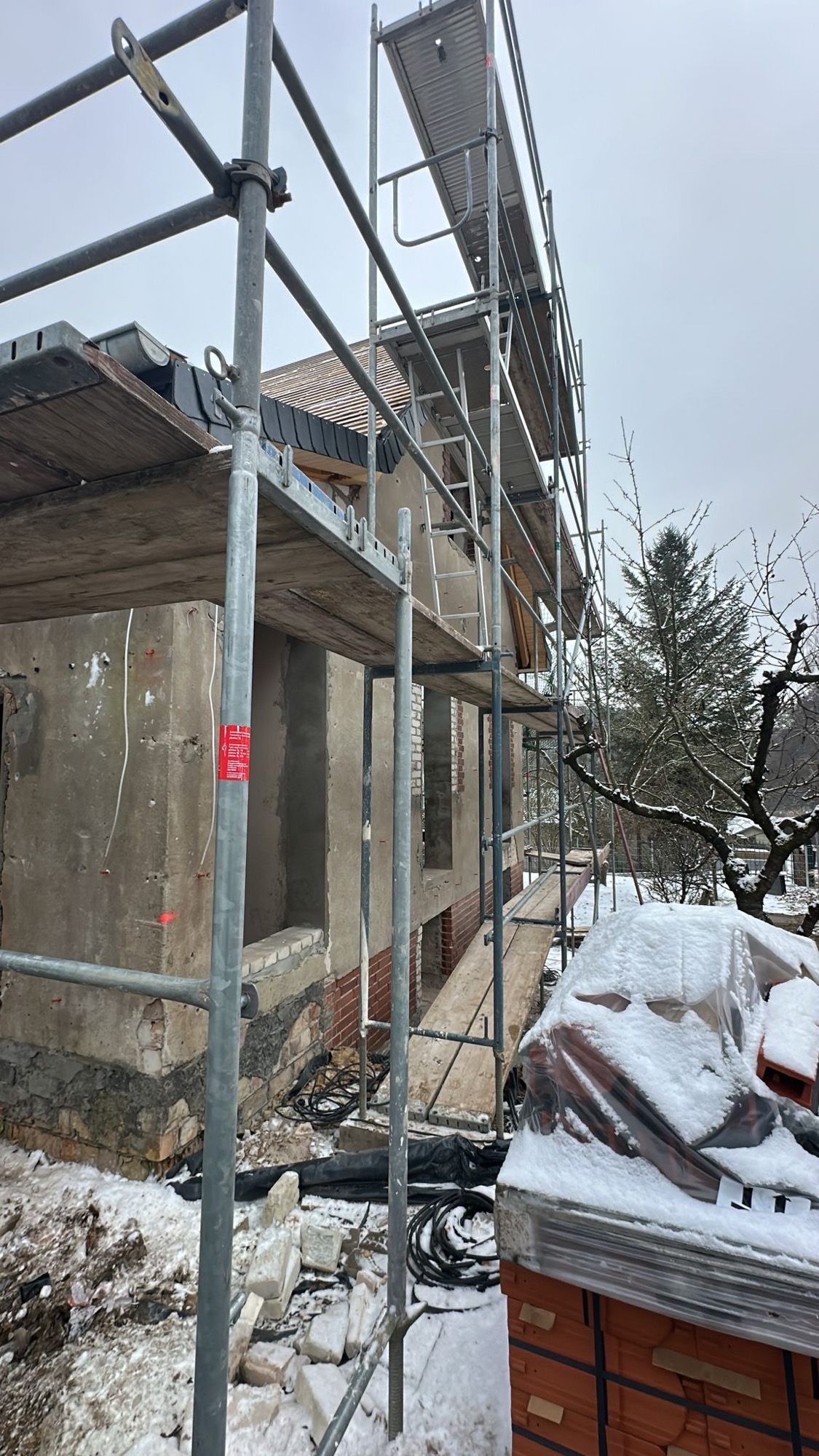 Seitliche Fassade Kernsanierung – Gerüst, leere Fensteröffnungen